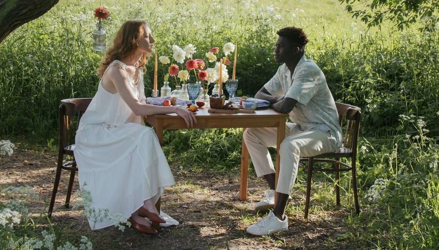 man and woman having a date near a field