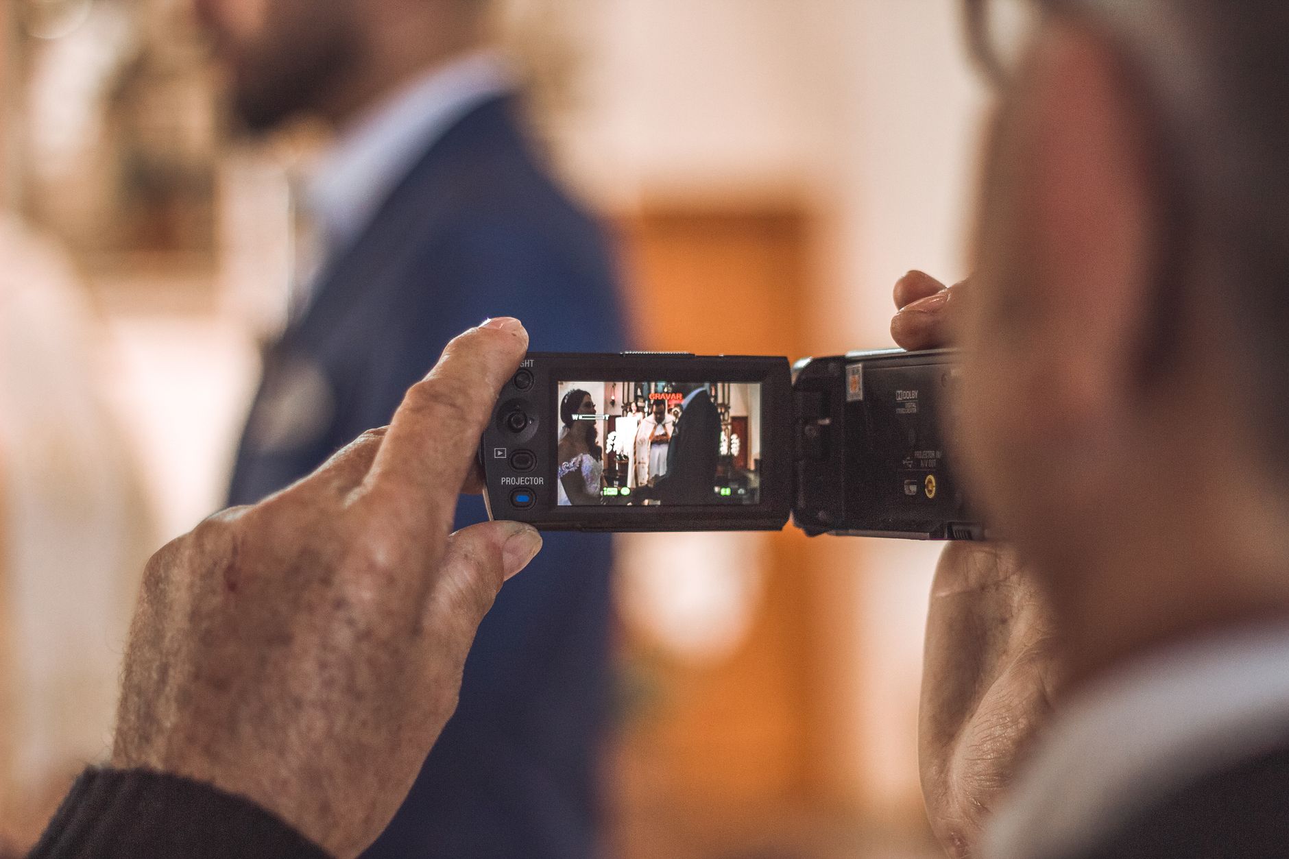 person filming the wedding using a camera